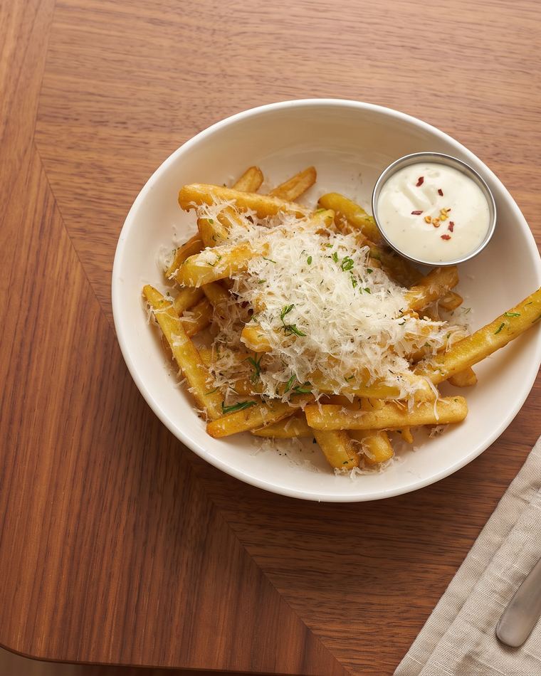 Truffle fries under grated parmesan and parsley, with confit garlic aioli on the side